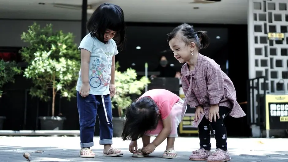 Anak membantu menyimpan sepatu di rak sebagai tanggung jawab kecilnya